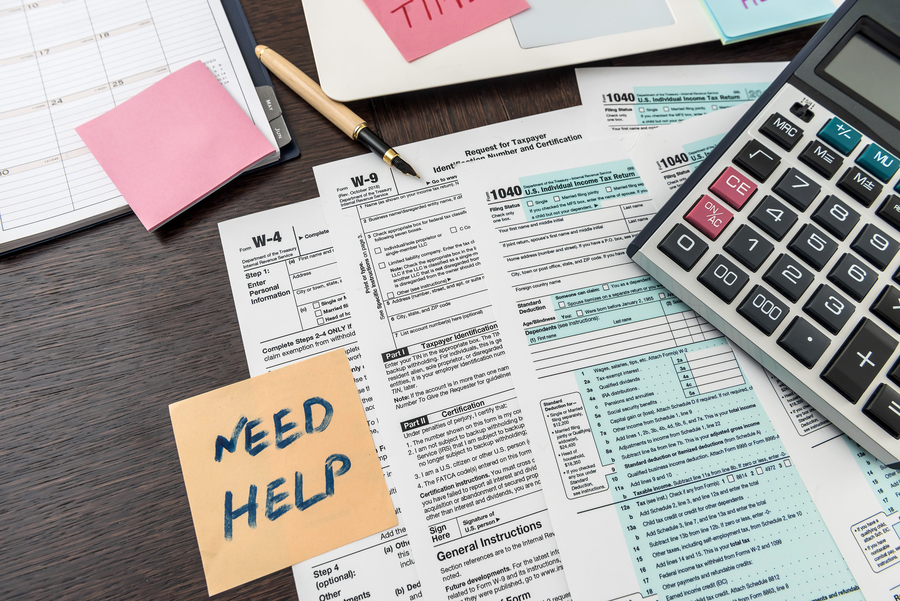 Federal 1040 tax form with sticker, calculator and pen. financial documents.